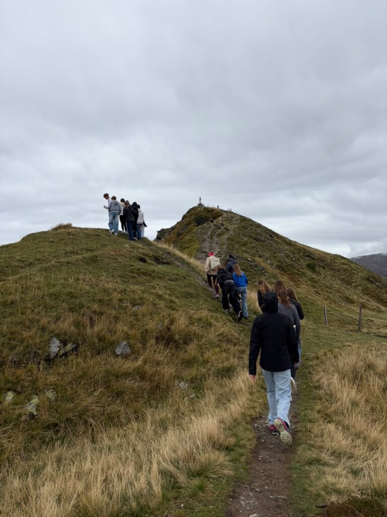 Wandergruppe auf Bergpfad in den österreichischen Alpen bei bedecktem Himmel