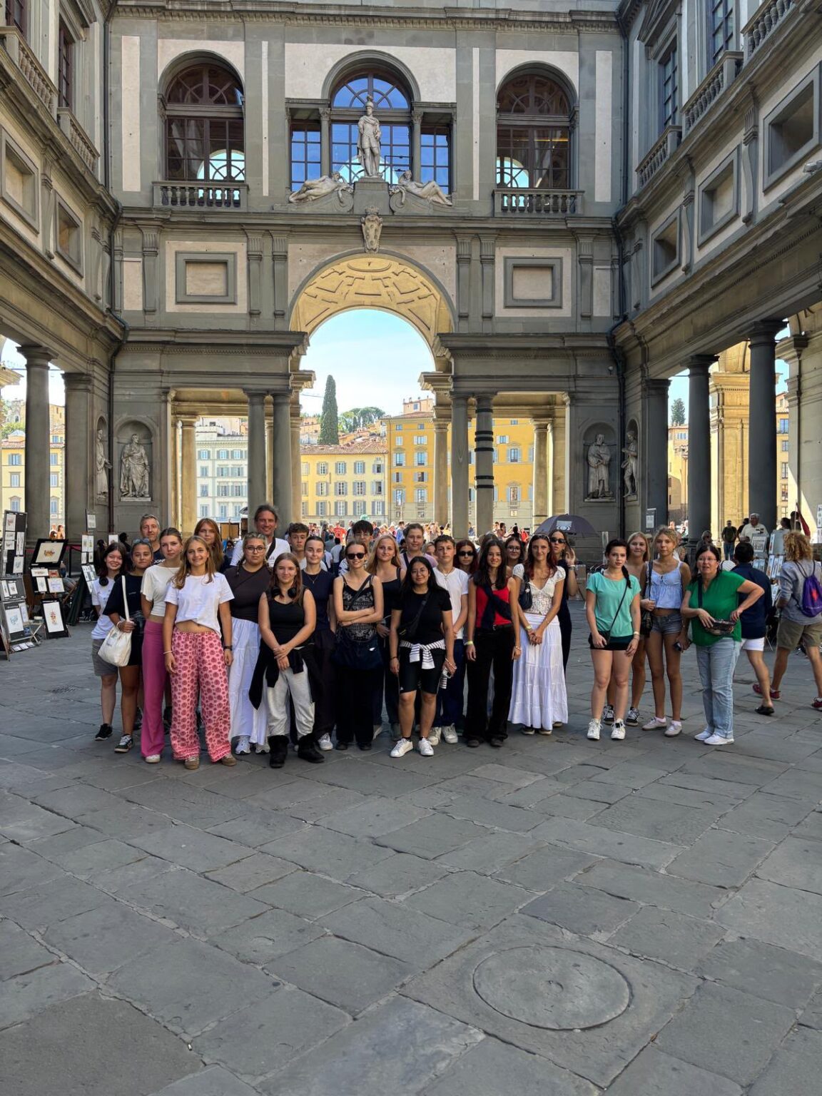 Gruppe von jungen Frauen und Männern vor dem Palazzo Vecchio in Florenz, Italien